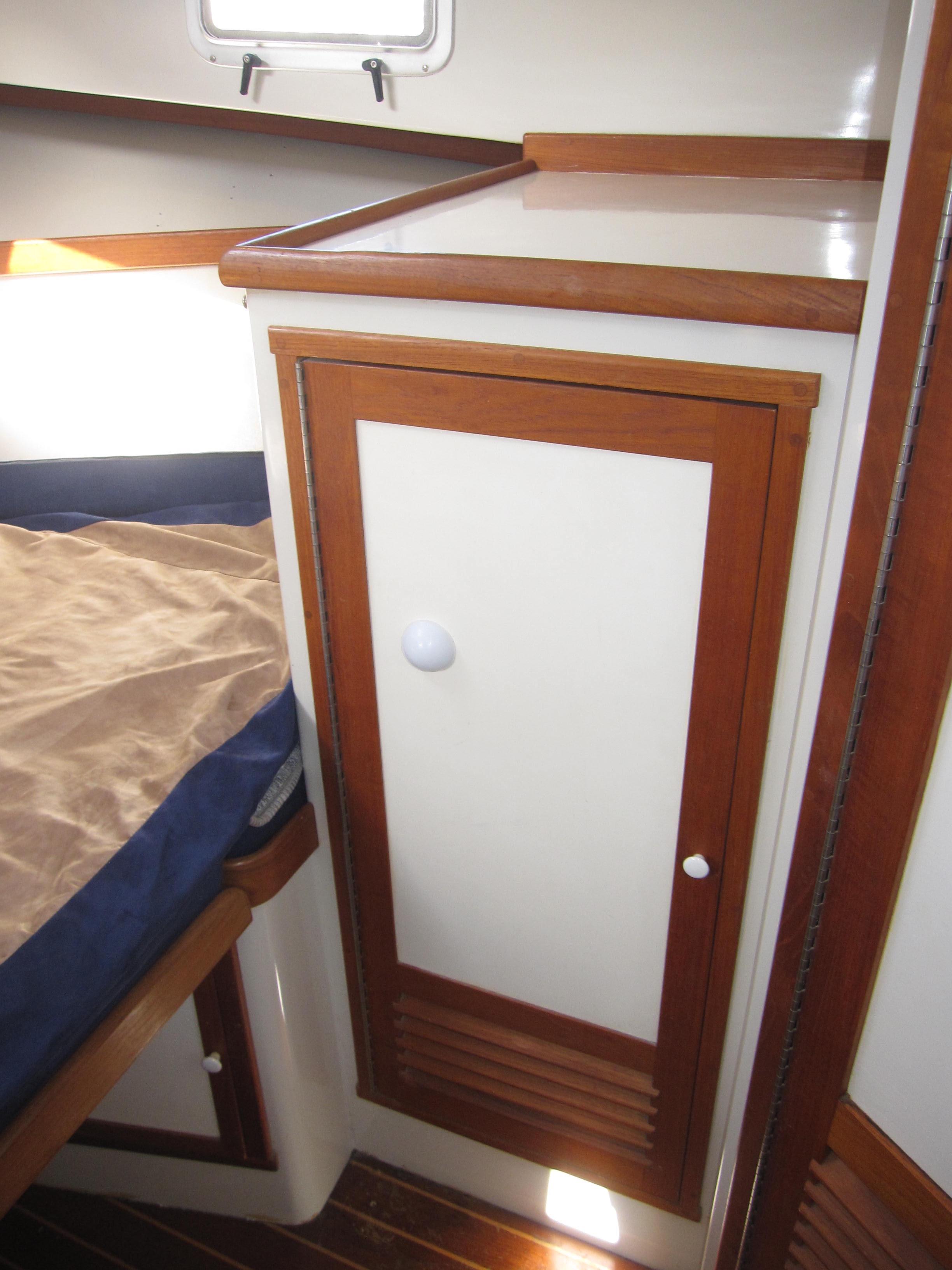 1990 Blue Seas 31 Hardtop Cruiser cabin interior with wooden cabinetry and bed.