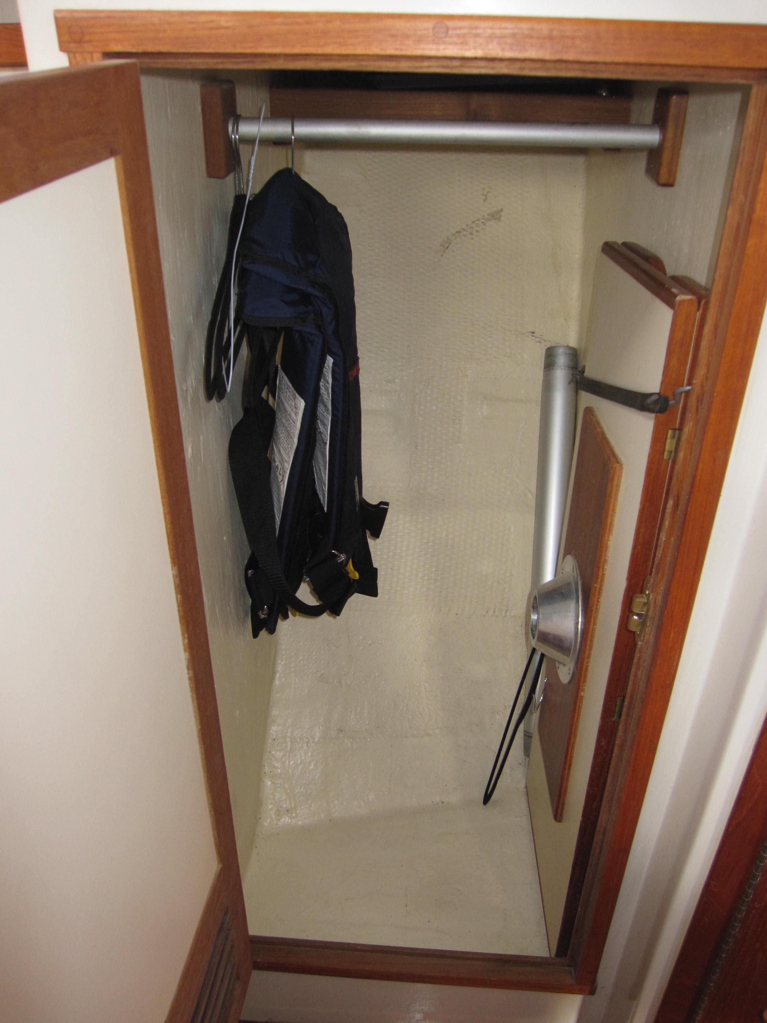 Small closet in a 1990 Blue Seas 31 Hardtop Cruiser with hanging clothes.
