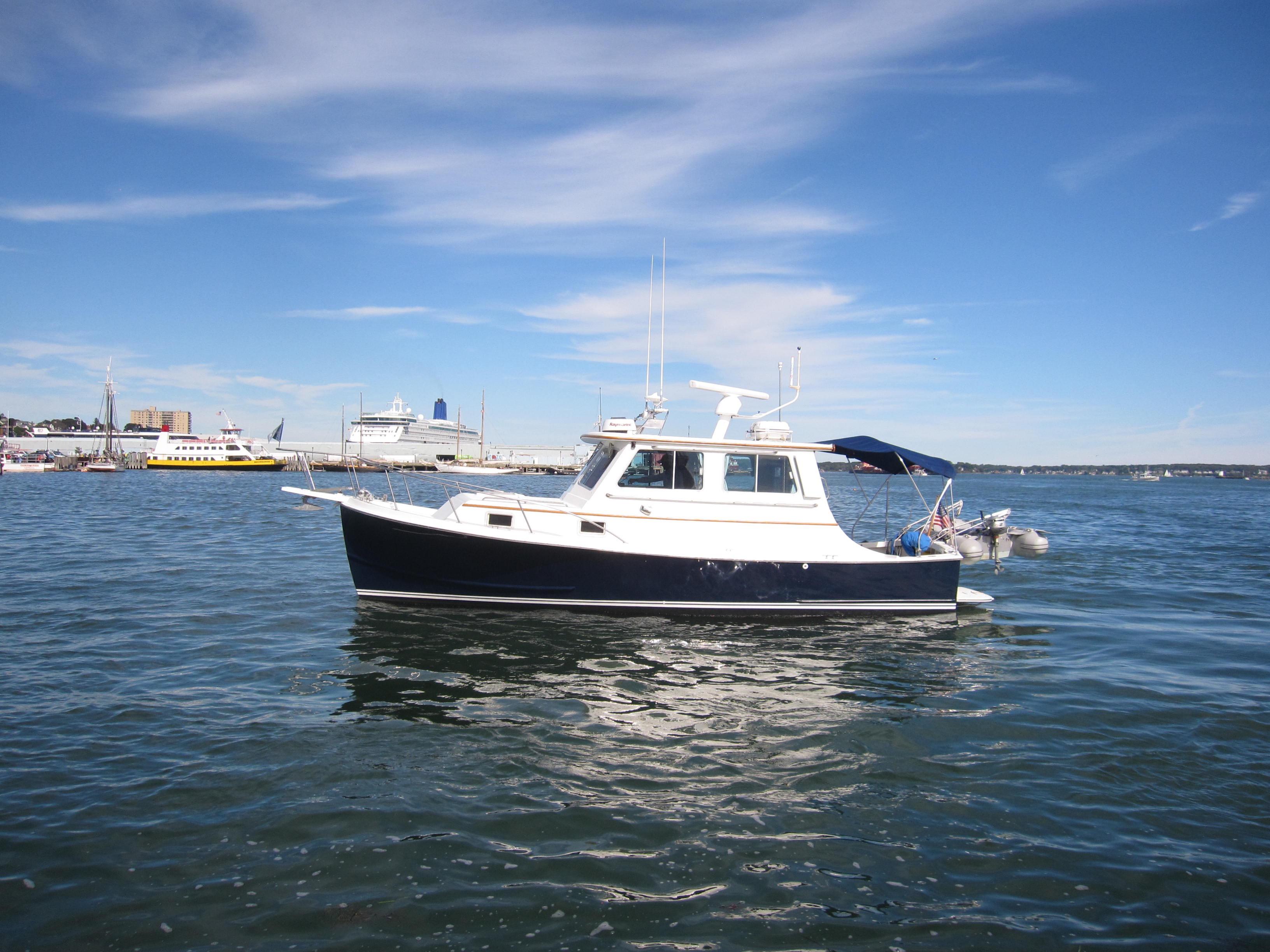 1990 Blue Seas 31 Hardtop Cruiser on calm water under a clear blue sky.