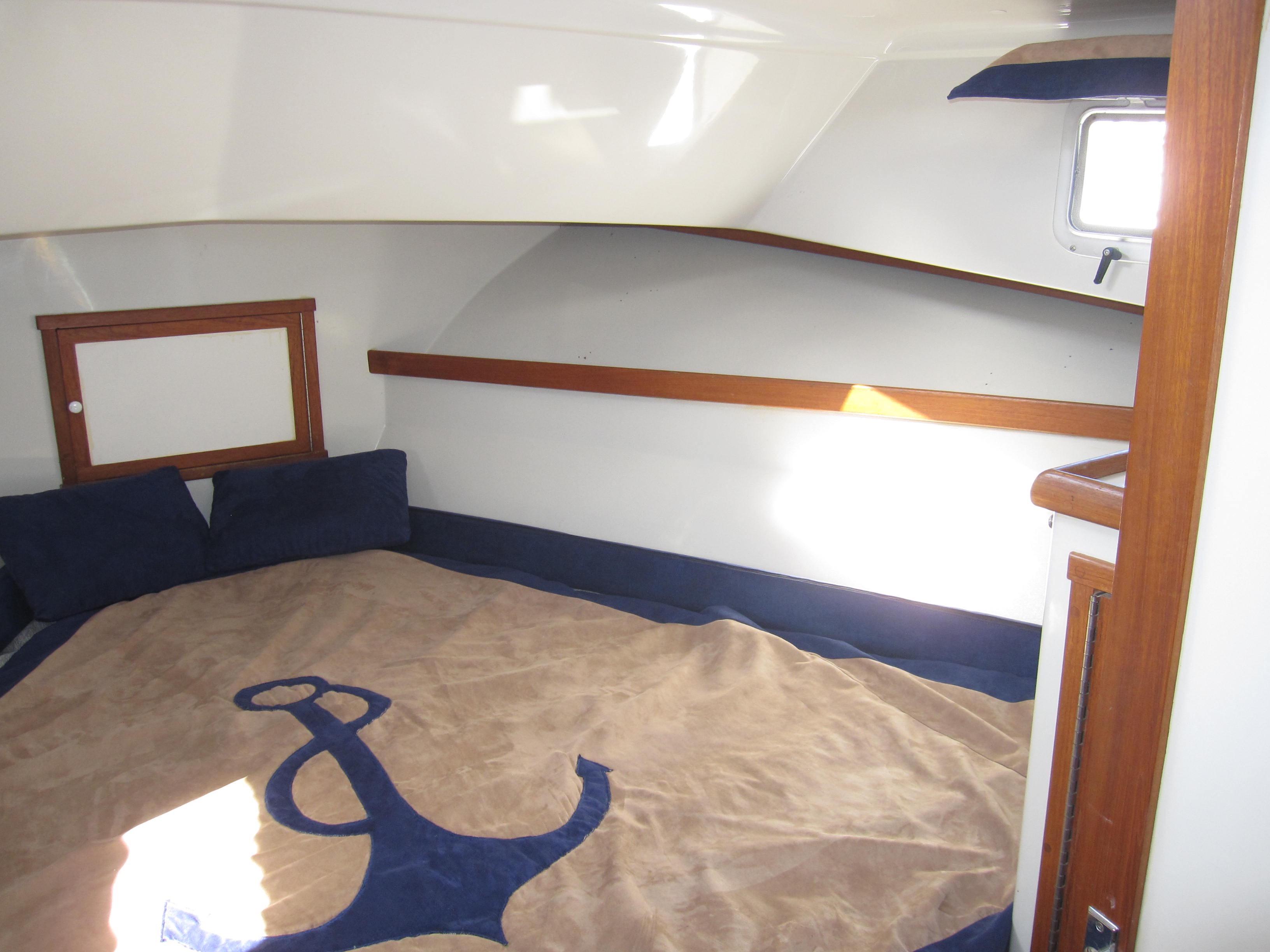 Interior cabin of a 1990 Blue Seas 31 Hardtop Cruiser with anchor-themed bedding.