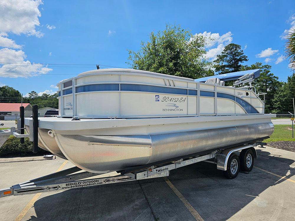 2022 Bennington 22 SXSB pontoon boat on trailer under clear blue sky.