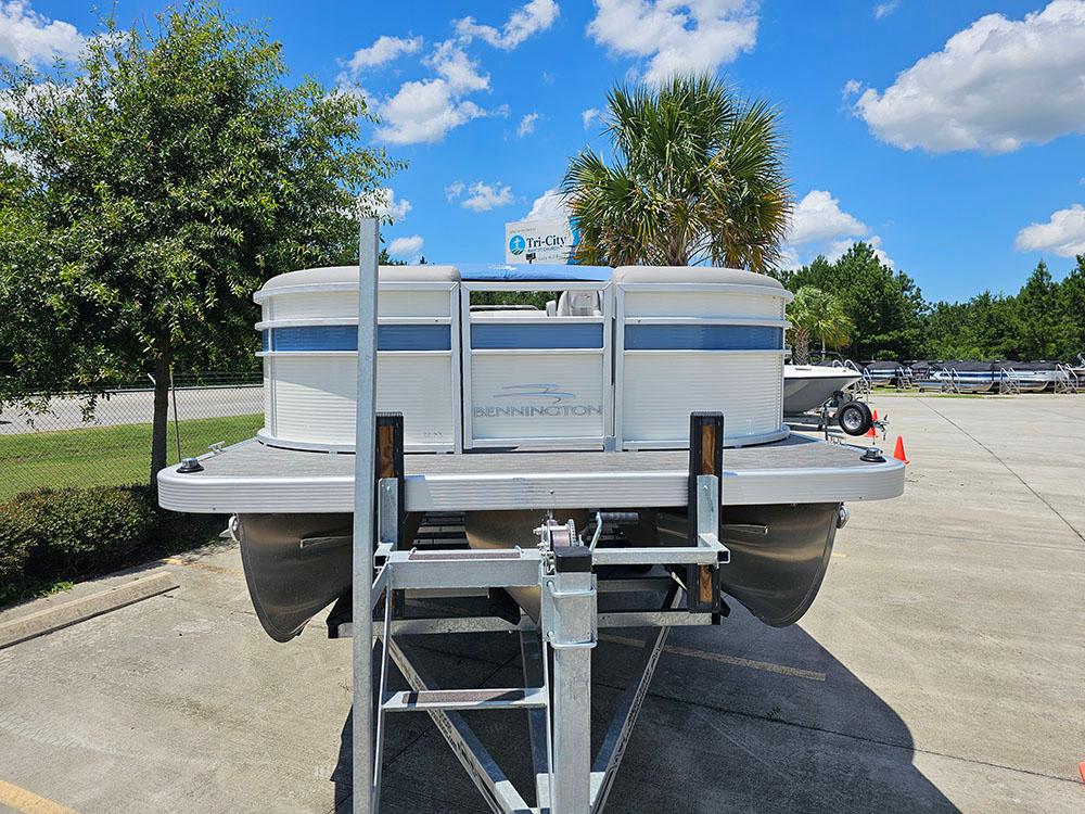 2022 Bennington 22 SXSB pontoon boat on trailer, sunny day, palm trees in background.