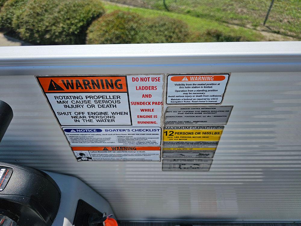 Warning labels on a 2022 Bennington 22 SXSB boat, highlighting safety and capacity information.