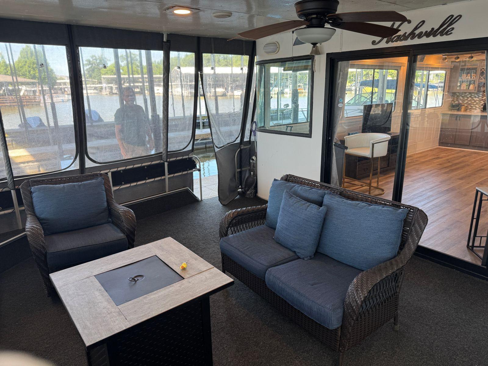 Stardust Cruisers-18 X 80 Houseboat 1986 -TN-US-1986 Stardust Cruisers 18 X 80 houseboat interior with seating, table, and ceiling fan.-9804797 | Thumbnail