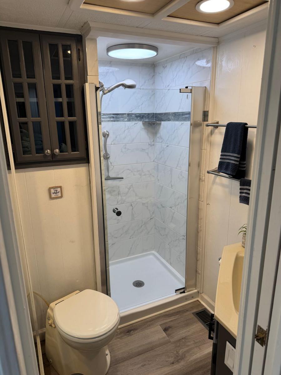 Stardust Cruisers-18 X 80 Houseboat 1986 -TN-US-Compact bathroom in 1986 Stardust Cruisers houseboat with shower, toilet, and storage cabinet.-9804797 | Thumbnail