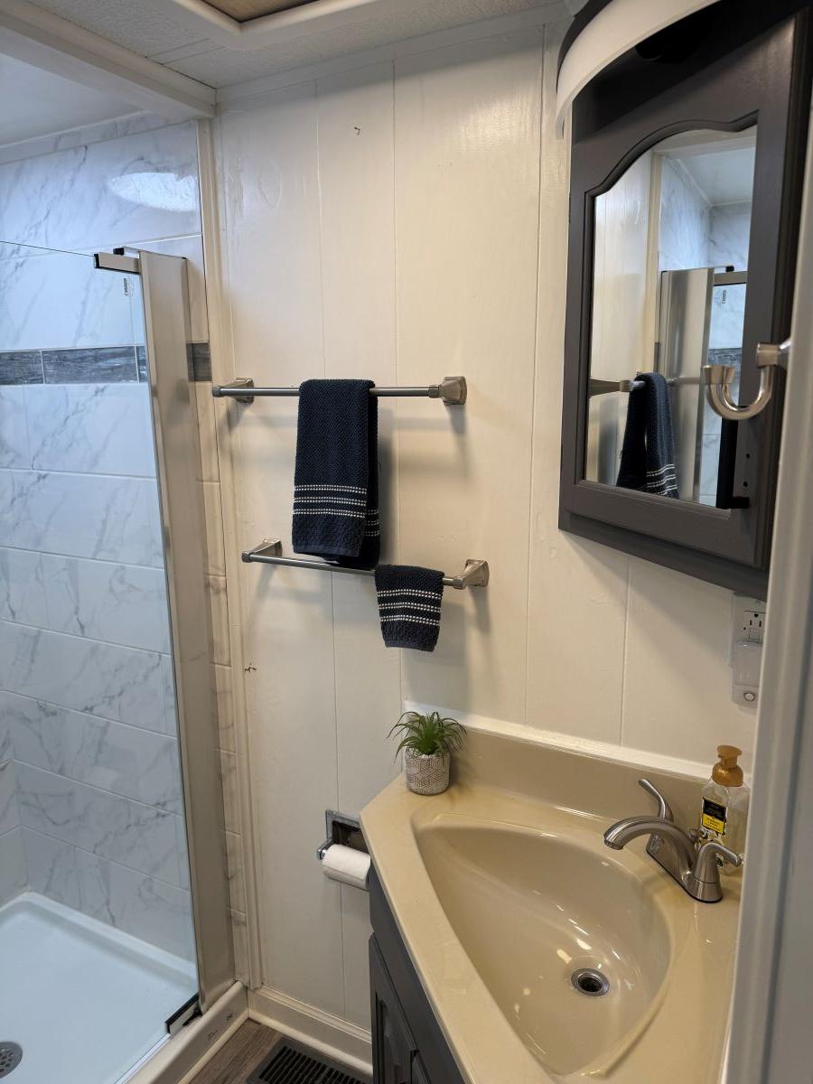 Stardust Cruisers-18 X 80 Houseboat 1986 -TN-US-1986 Stardust Cruisers houseboat bathroom with shower, sink, mirror, and towel rack.-9804797 | Thumbnail