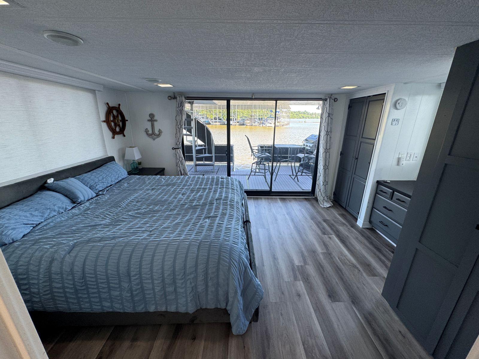 Stardust Cruisers-18 X 80 Houseboat 1986 -TN-US-1986 Stardust Cruisers houseboat bedroom with large bed, nautical decor, and sliding glass doors to deck.-9804797 | Thumbnail