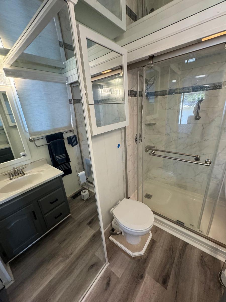 Stardust Cruisers-18 X 80 Houseboat 1986 -TN-US-1986 Stardust Cruisers houseboat bathroom with modern shower, vanity, and wood flooring.-9804797 | Thumbnail