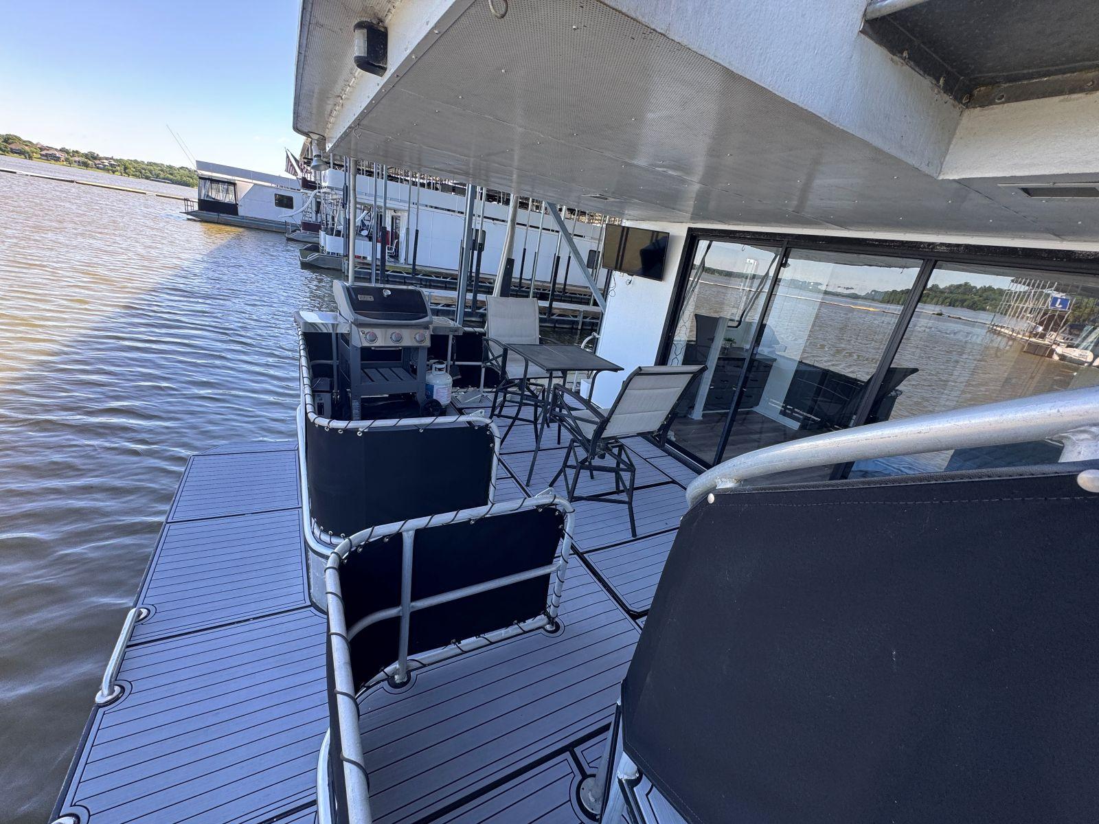 Stardust Cruisers-18 X 80 Houseboat 1986 -TN-US-1986 Stardust Cruisers 18 X 80 houseboat with outdoor seating on a calm lake.-9804797 | Thumbnail