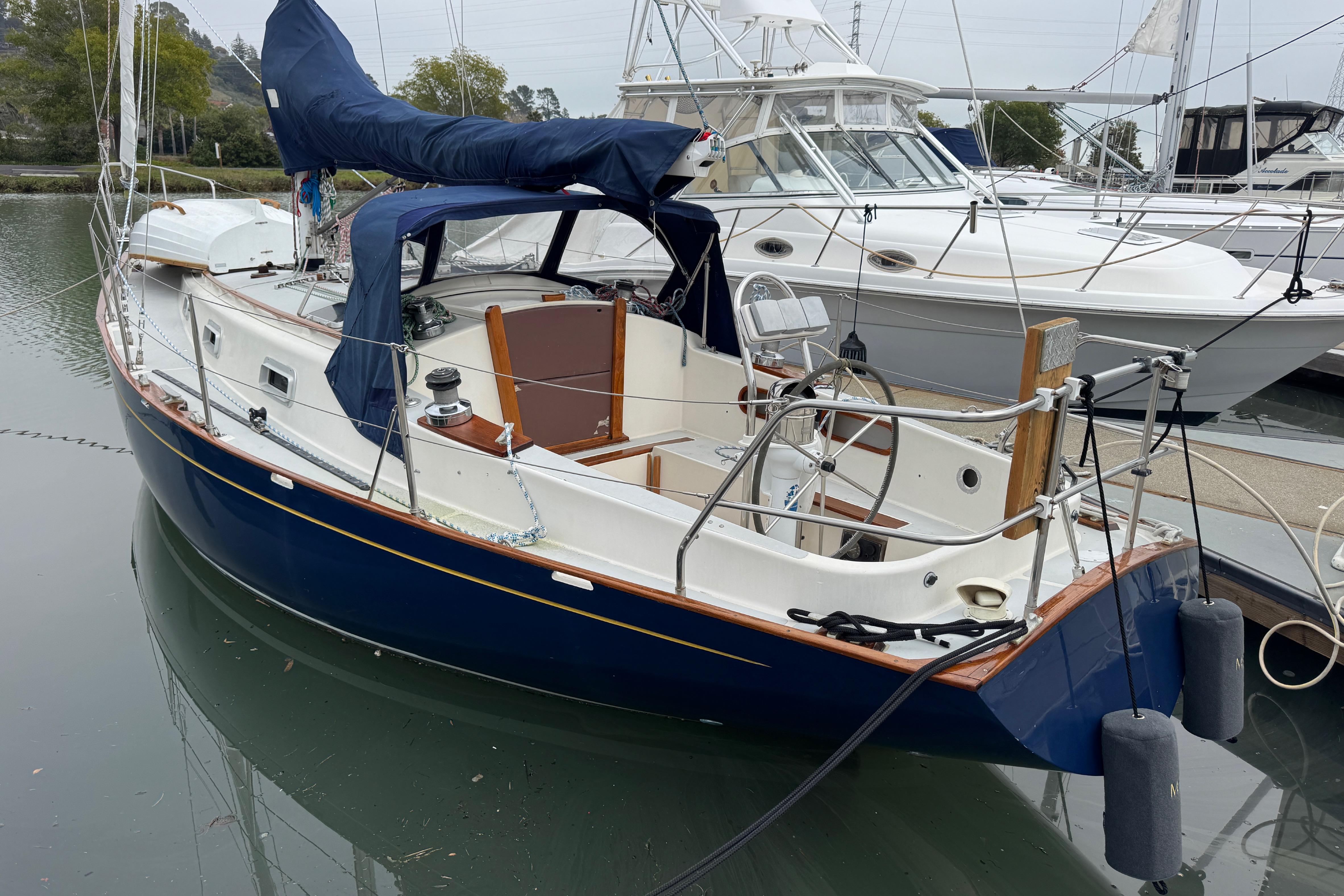 1990 Contessa 32 sailboat docked in marina, featuring blue hull and white deck.