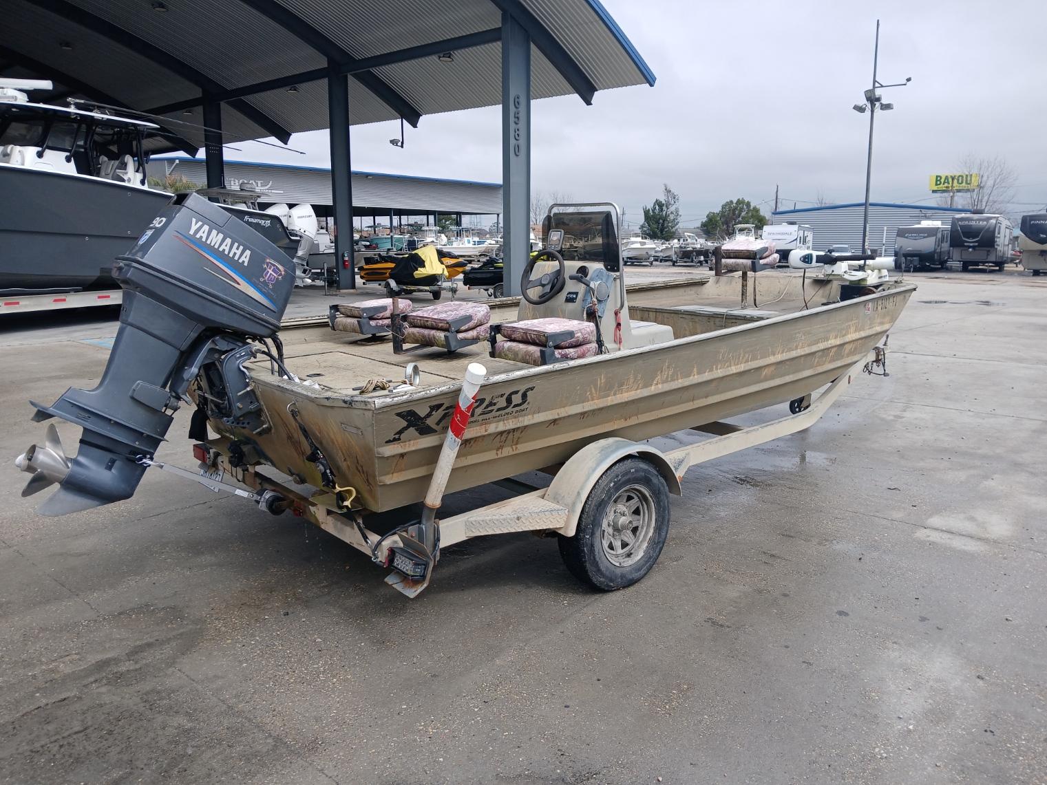 2004 Xpress 18 boat with Yamaha outboard motor on trailer at marina.