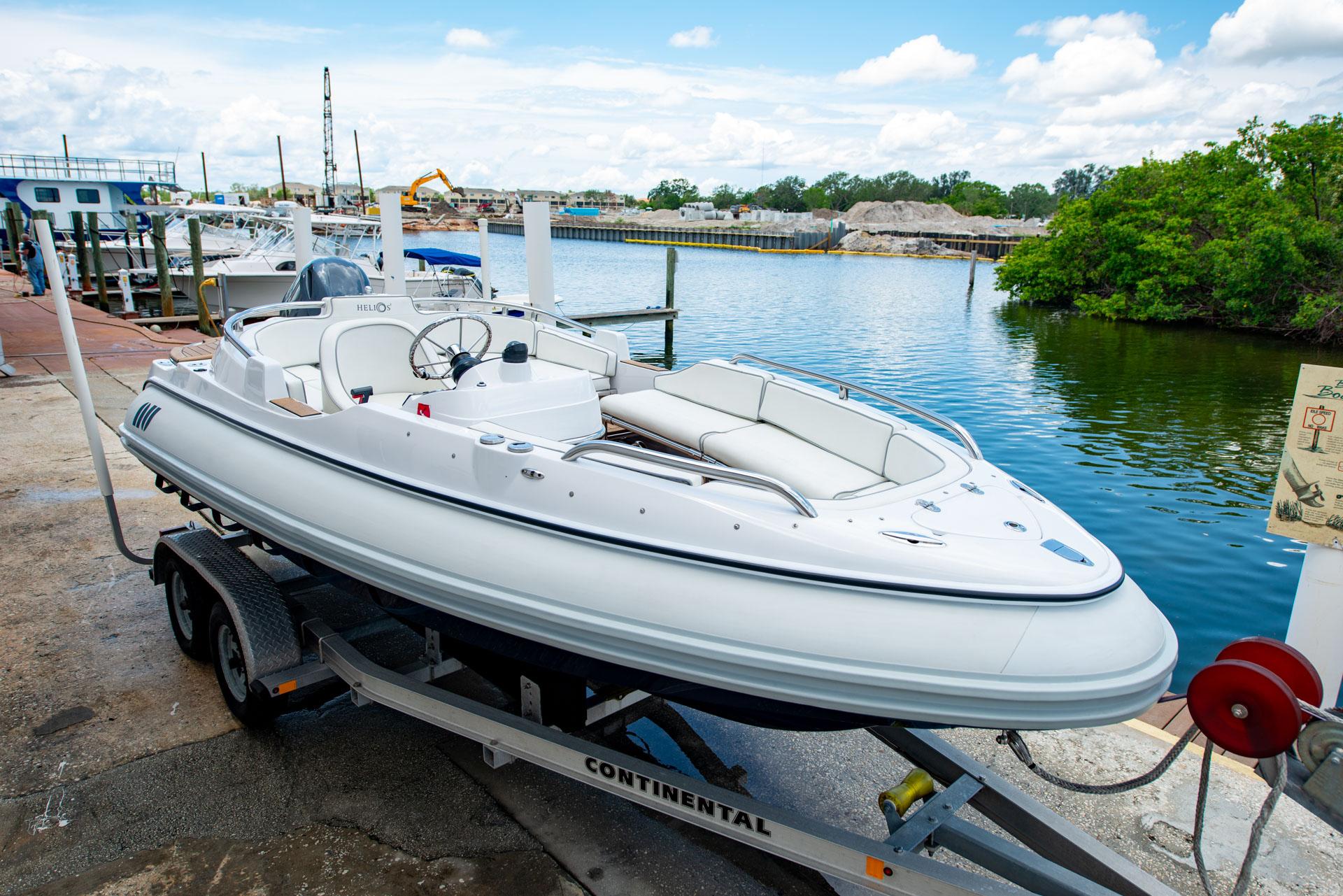 2006 Novurania RHIB boat on trailer by waterfront, under clear blue sky.