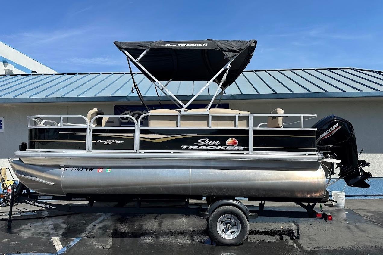 2022 Sun Tracker Bass Buggy 18 DLX pontoon boat on trailer, with Mercury outboard motor.