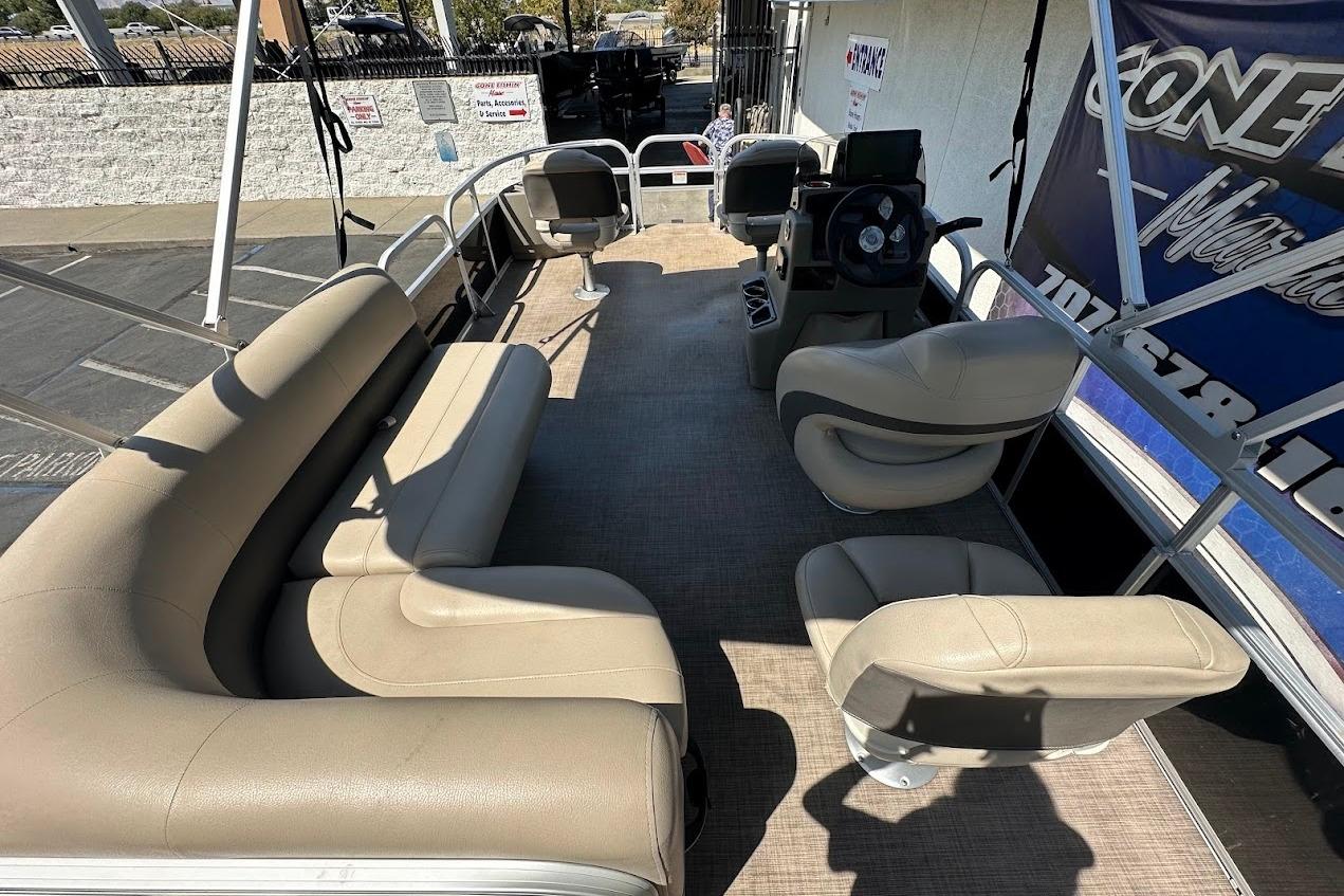 2022 Sun Tracker Bass Buggy 18 DLX pontoon boat interior with beige seating and steering console.