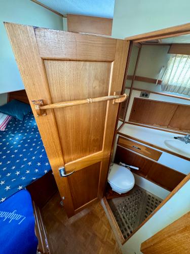 1979 Grand Banks Classic boat interior with wooden door, cozy cabin, and compact bathroom.