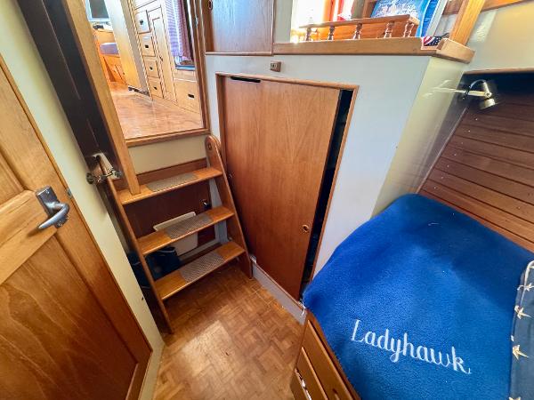 1979 Grand Banks Classic interior with wooden stairs and cozy sleeping area.