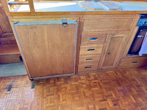 1979 Grand Banks Classic wooden kitchen interior with parquet flooring and cabinetry.