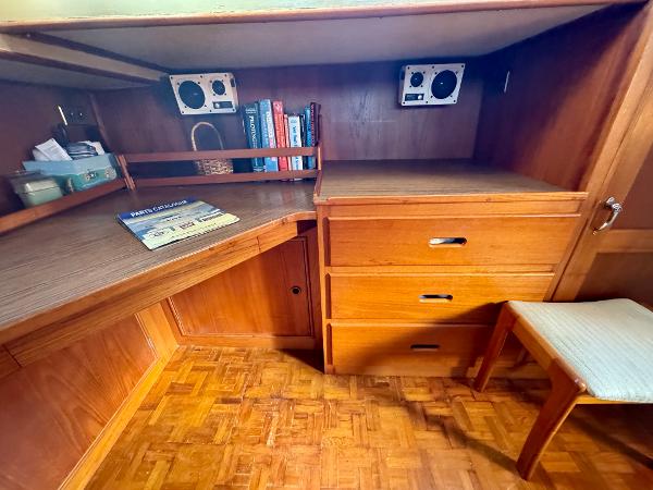 1979 Grand Banks Classic interior with wooden desk, books, and drawers.