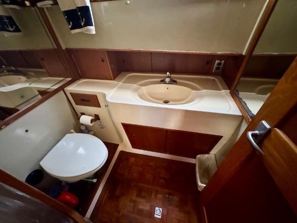 1979 Grand Banks Classic yacht bathroom with sink, toilet, and wood accents.