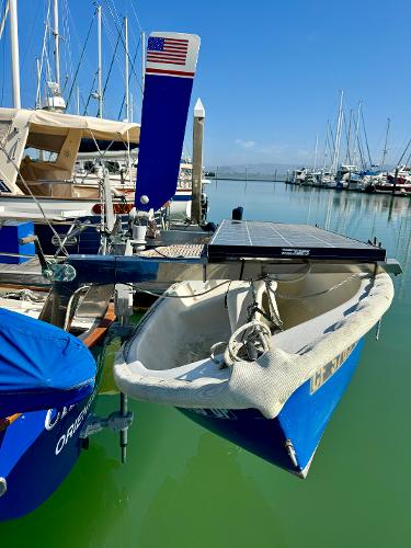 1975 Salar 40 sailboat docked in marina, featuring solar panel and American flag.