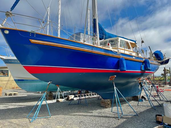 Blue 1975 Salar 40 sailboat on stands in a boatyard.