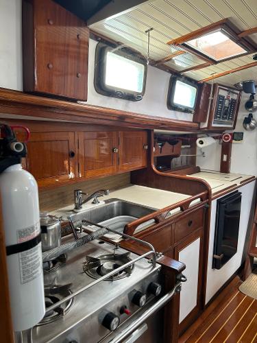 1975 Salar 40 yacht kitchen with wooden cabinets, stove, and sink.