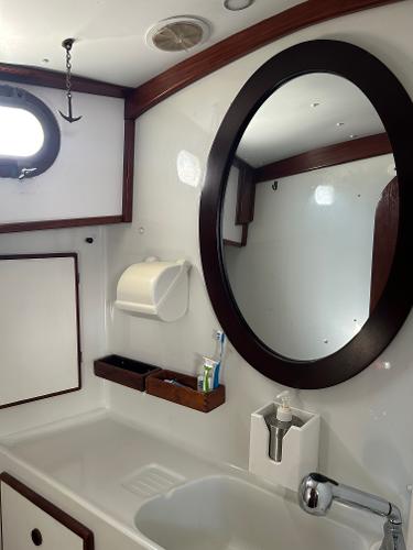 Vintage 1975 Salar 40 yacht bathroom with oval mirror and wooden accents.