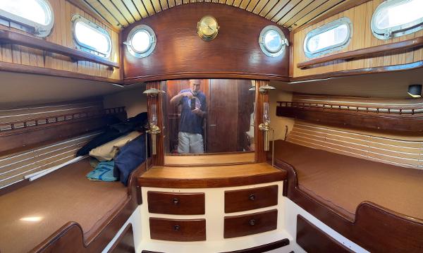 Interior of a 1975 Salar 40 sailboat cabin with wooden furnishings and portholes.