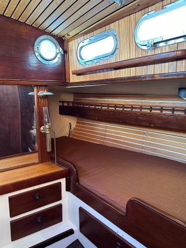 Interior of a 1975 Salar 40 sailboat with wooden paneling and cozy berth.