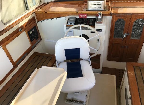 Interior of a 1975 Salar 40 boat, featuring a steering wheel and captain's chair.