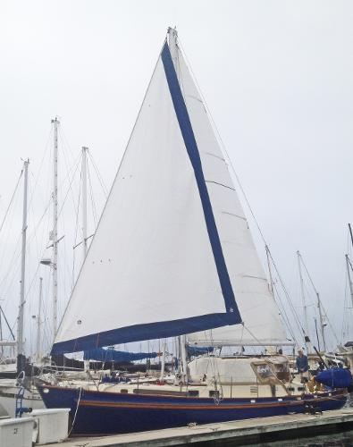 1975 Salar 40 sailboat docked at a marina, featuring a large white sail.