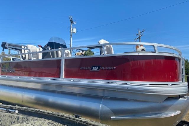 2026 Sun Tracker Bass Buggy 18 DLX pontoon boat with red exterior on display.