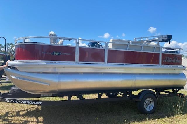 2026 Sun Tracker Bass Buggy 18 DLX pontoon boat on trailer, sunny day.