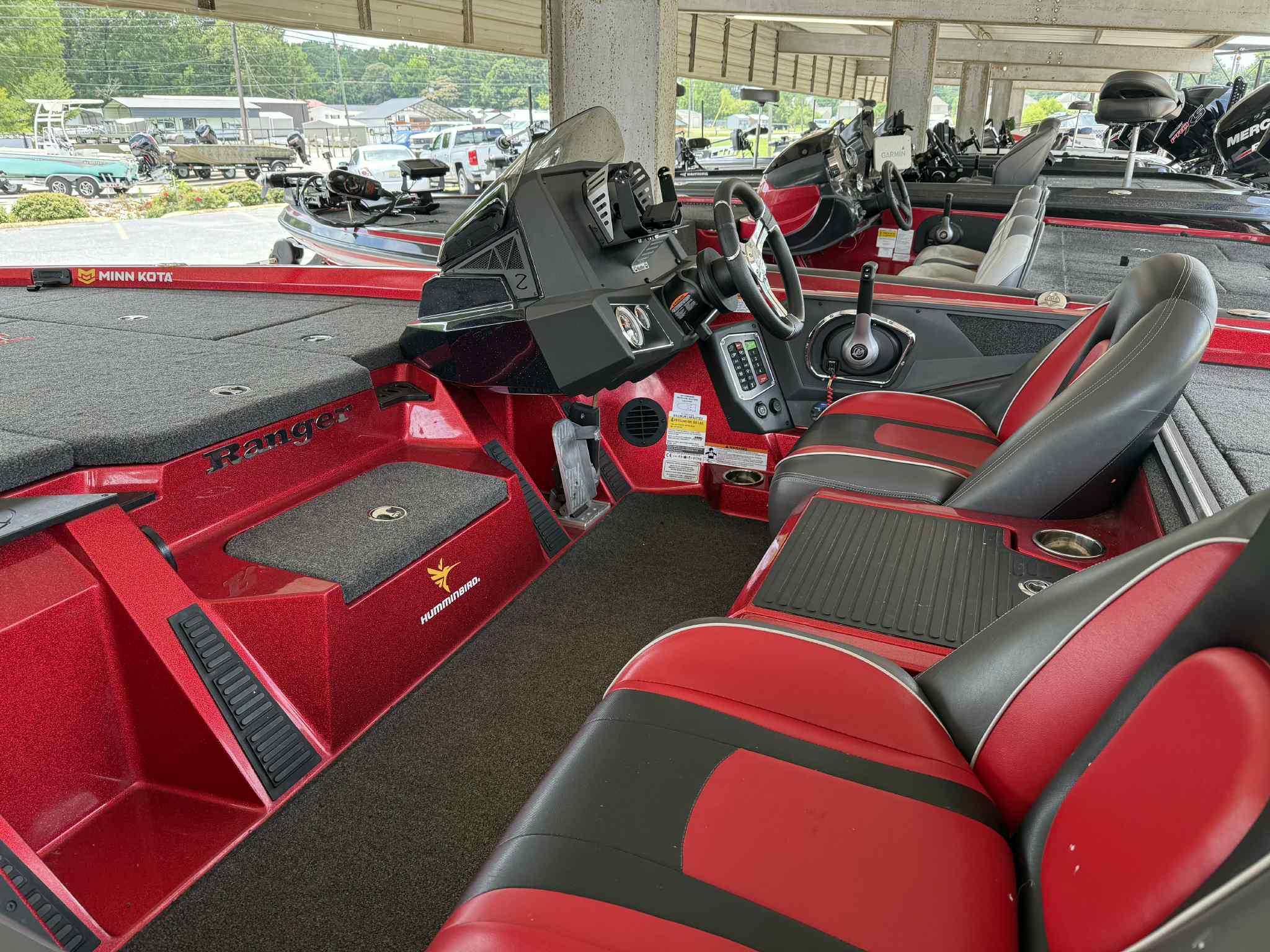 2022 Ranger Z518 boat interior with red and black seating, steering console, and fishing equipment.