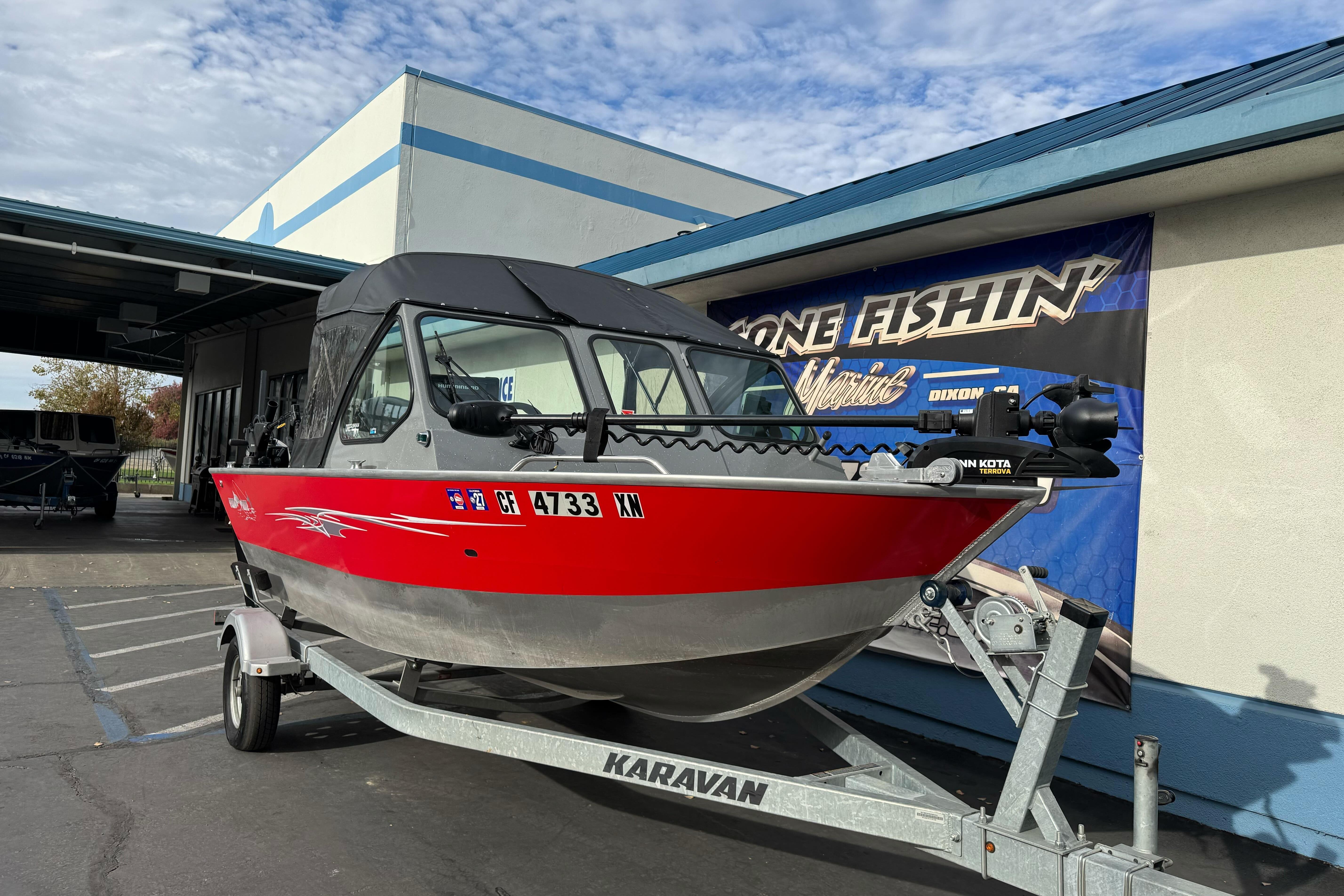 2018 Fish Rite 16.5 Stalker boat on Karavan trailer, parked outside a building.