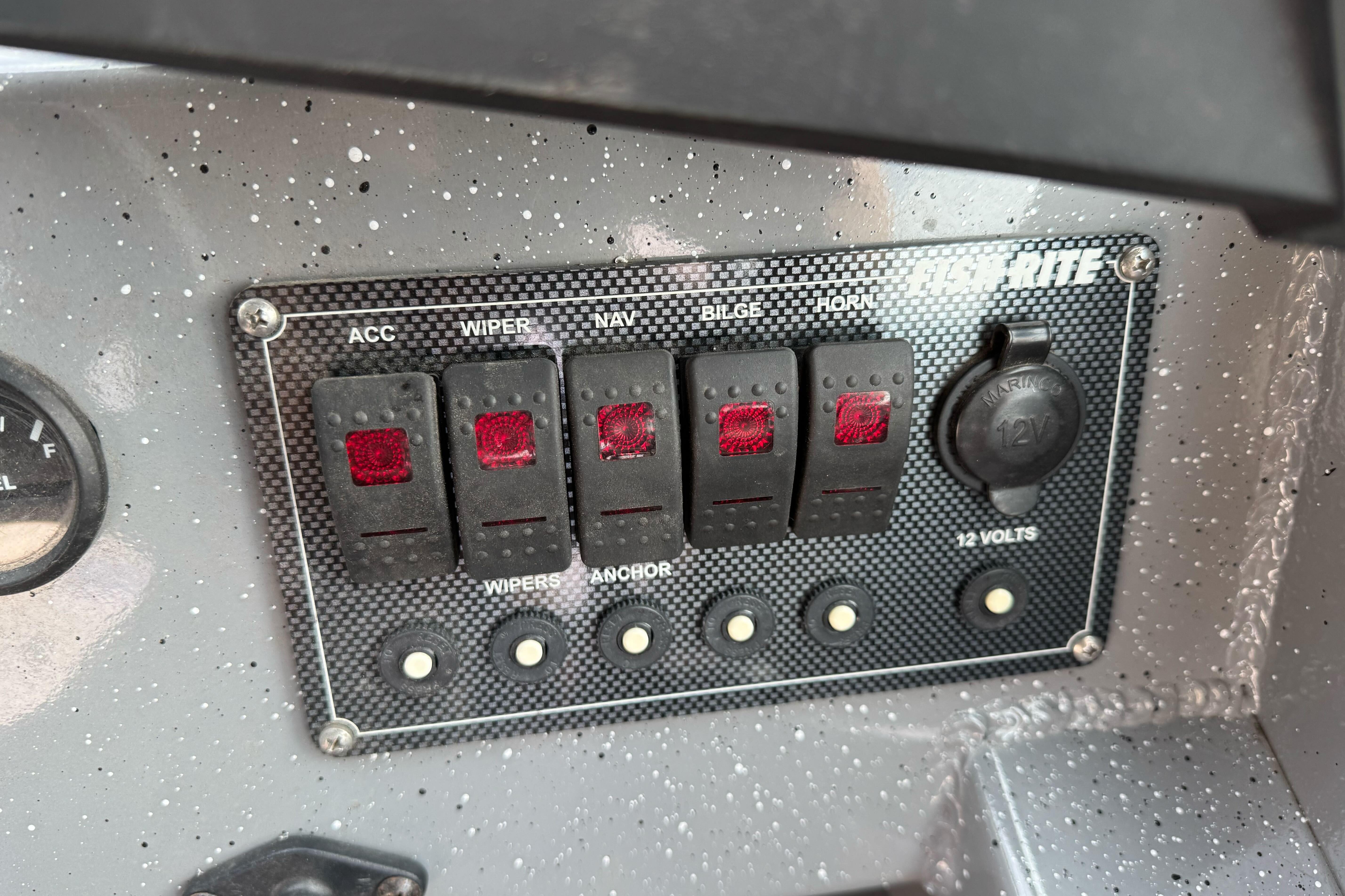 Control panel of a 2018 Fish Rite 16.5 Stalker boat with switches and 12V outlet.