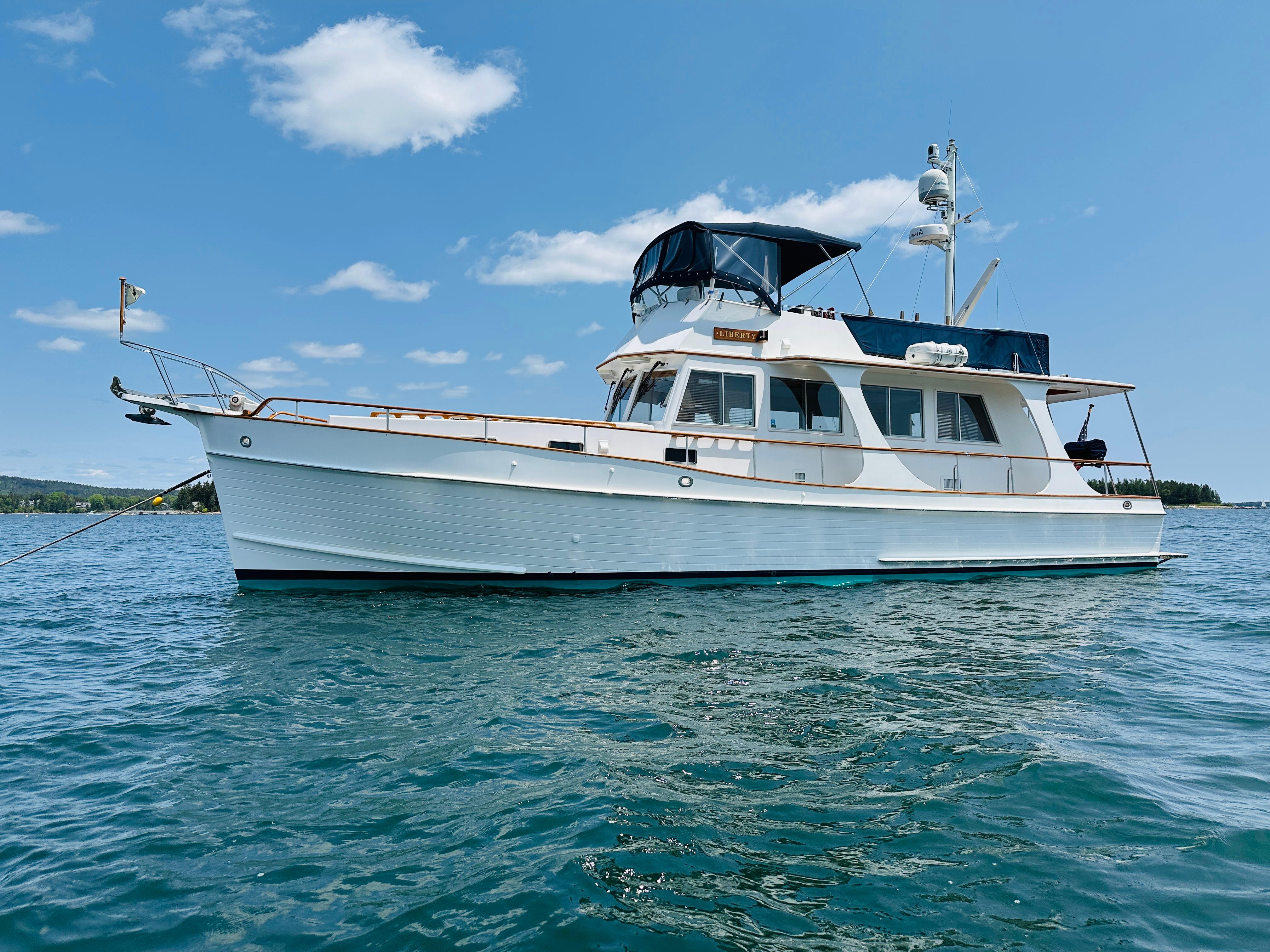2003 Grand Banks 46 Europa yacht on calm blue water under clear sky.