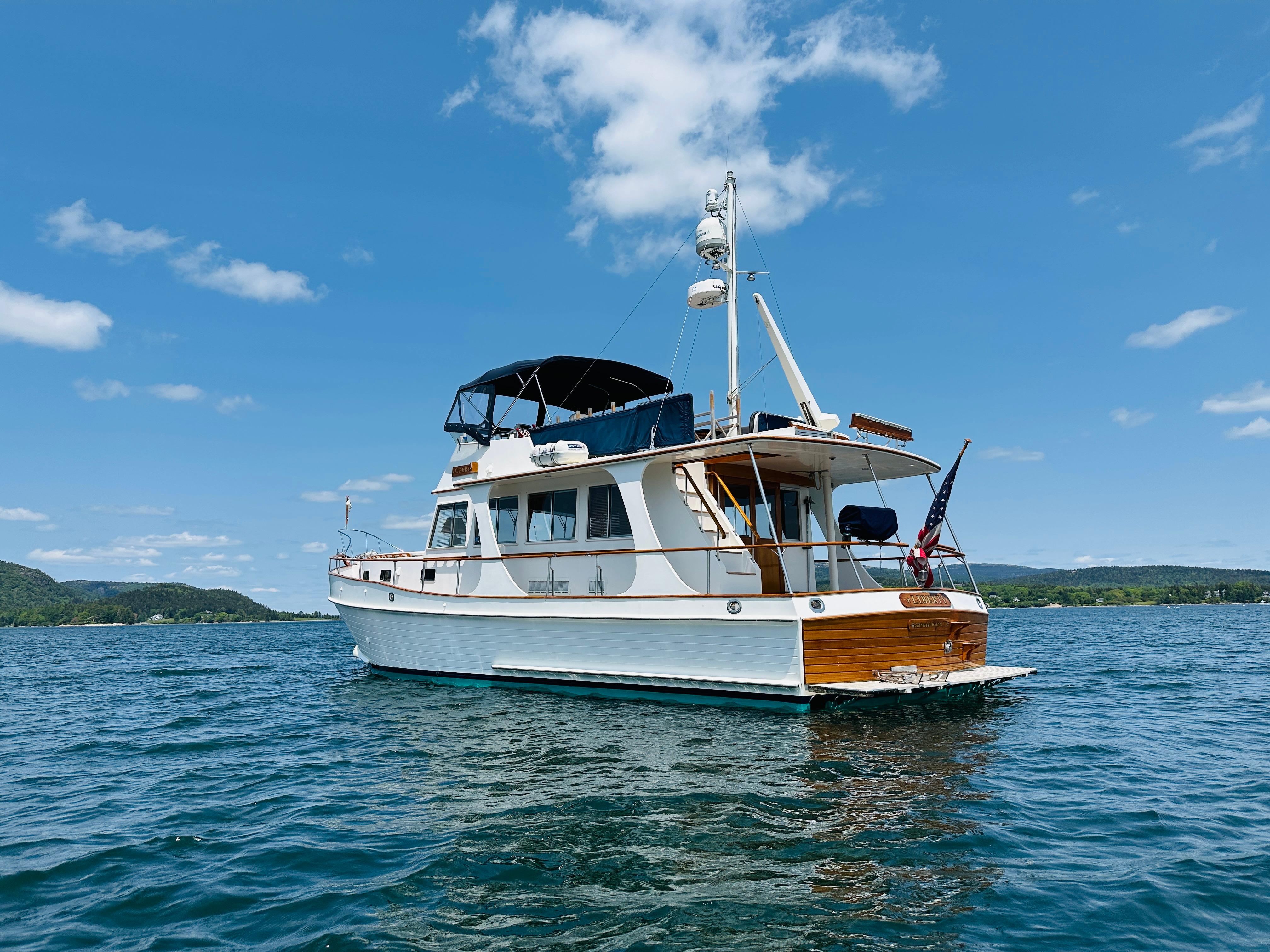 2003 Grand Banks 46 Europa yacht on a sunny day, cruising on calm waters.