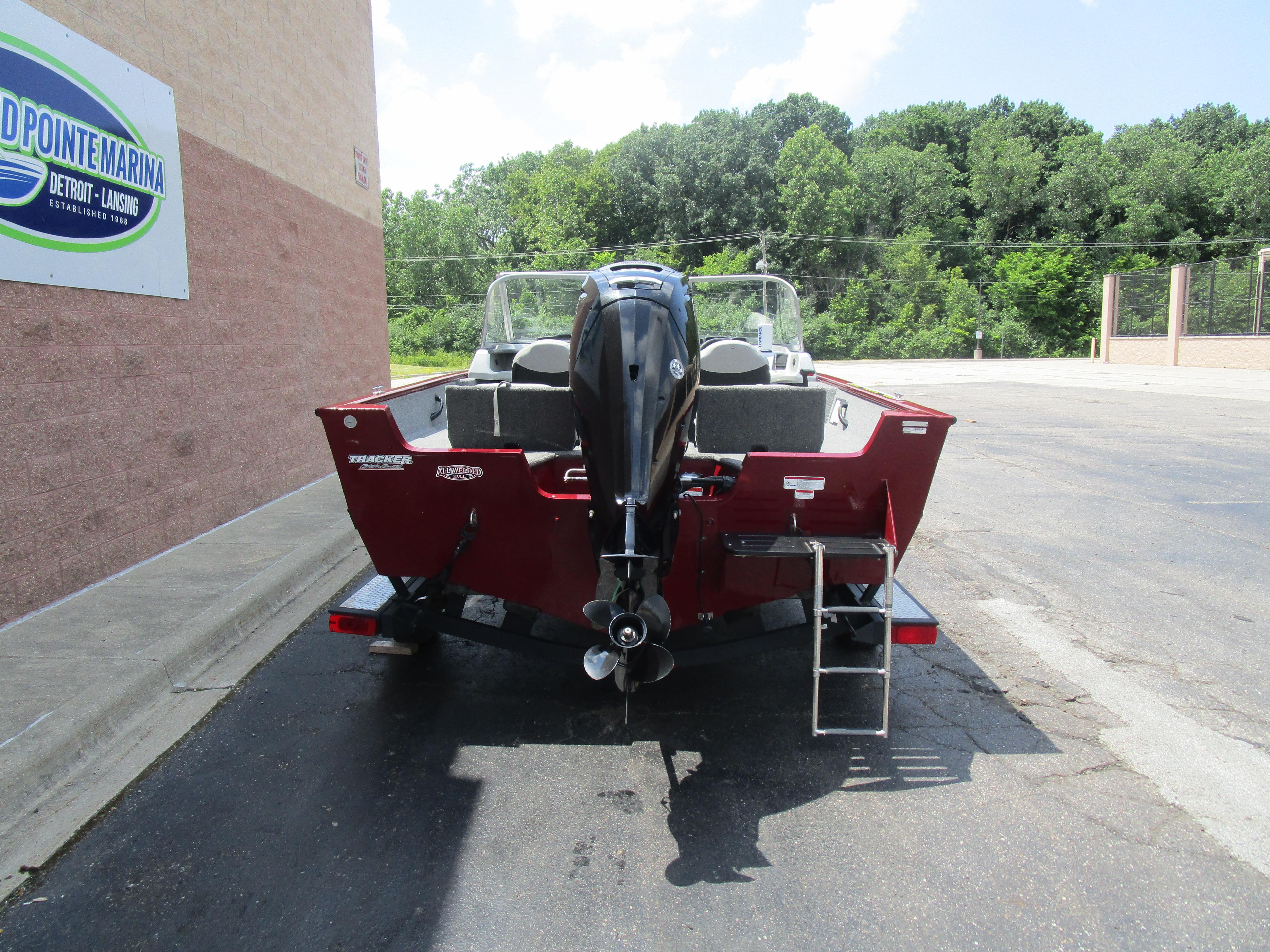 2017 Tracker PGV175 COMBO boat parked at marina, rear view with outboard motor.