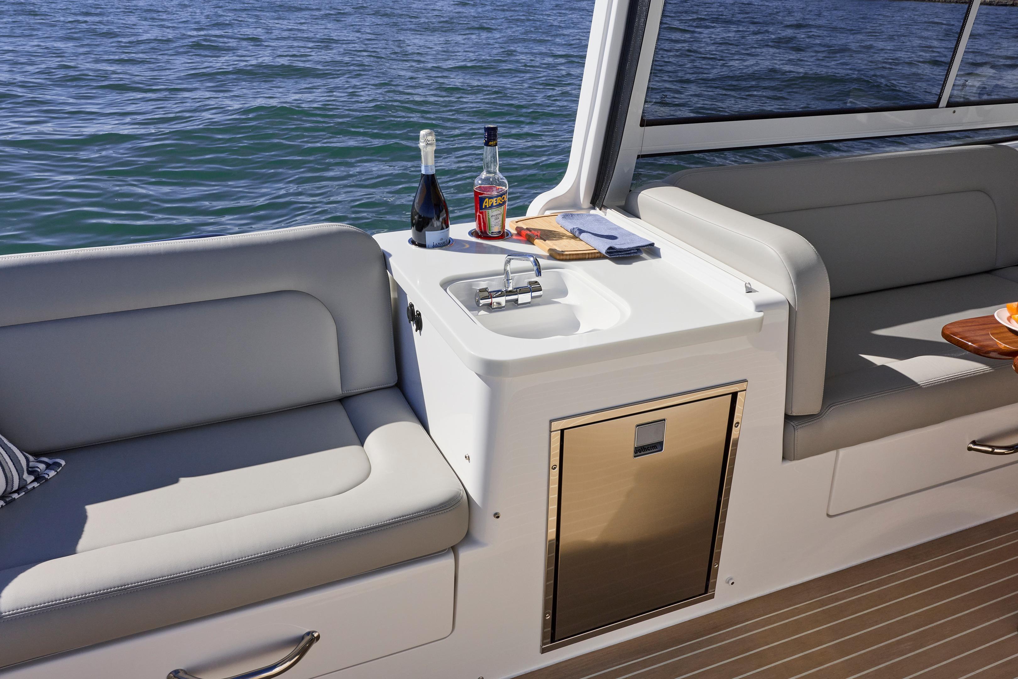 Luxury seating area on MJM 38x 2026 boat with drinks and sink.