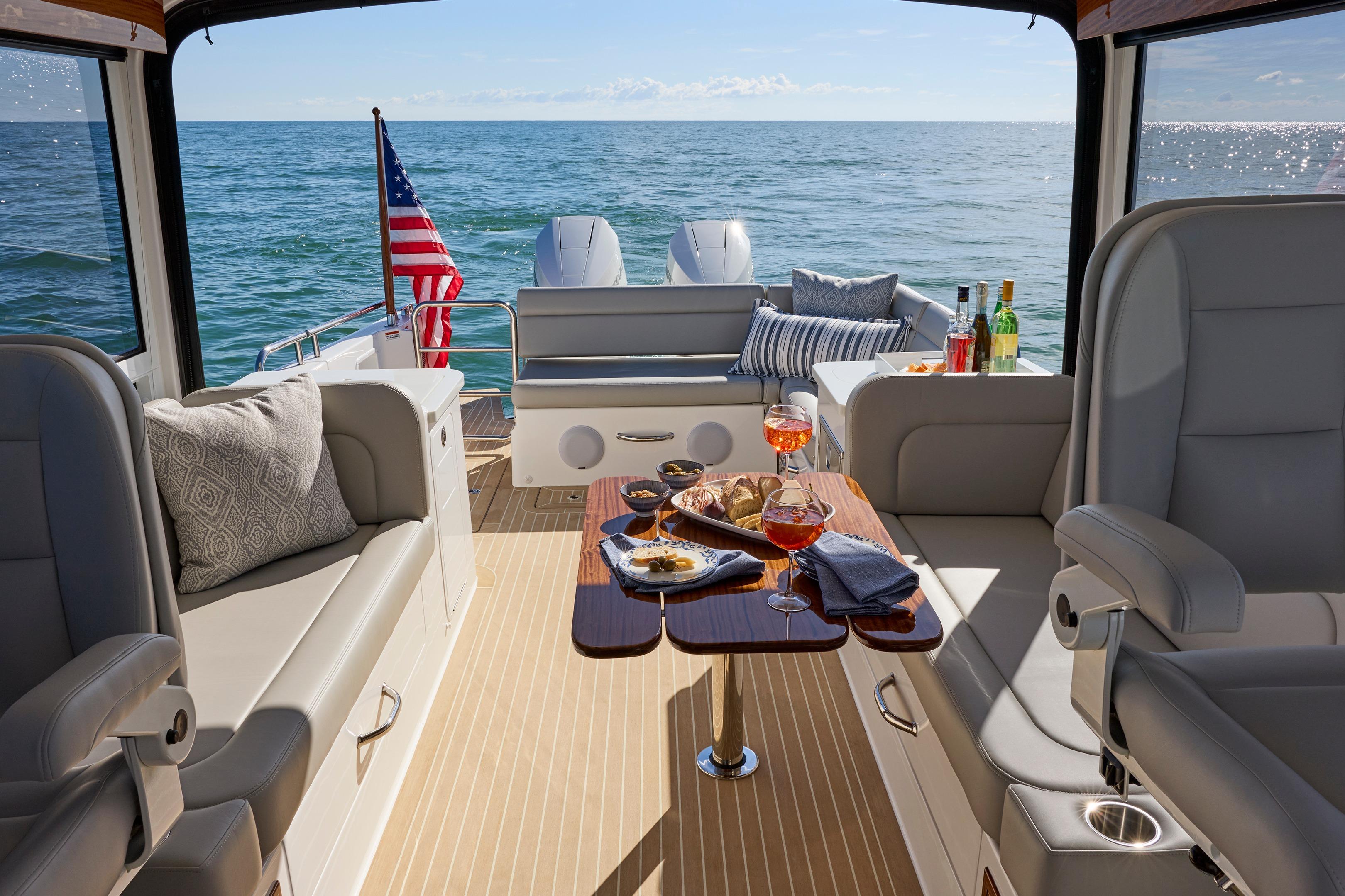 Luxurious MJM 38x yacht interior with elegant seating, table setting, and ocean view, 2026 model.