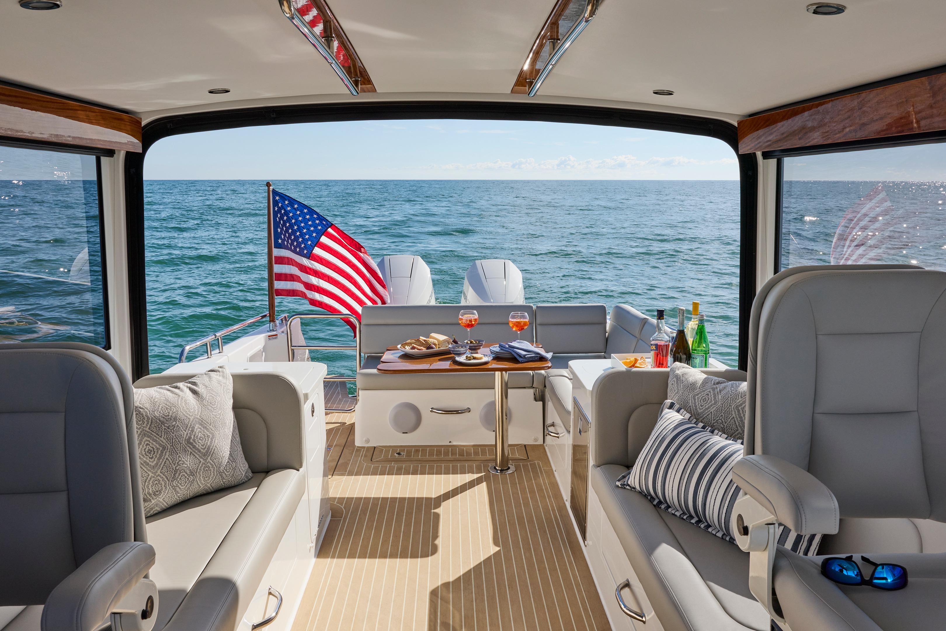 Luxurious 2026 MJM 38x yacht interior with ocean view and American flag.