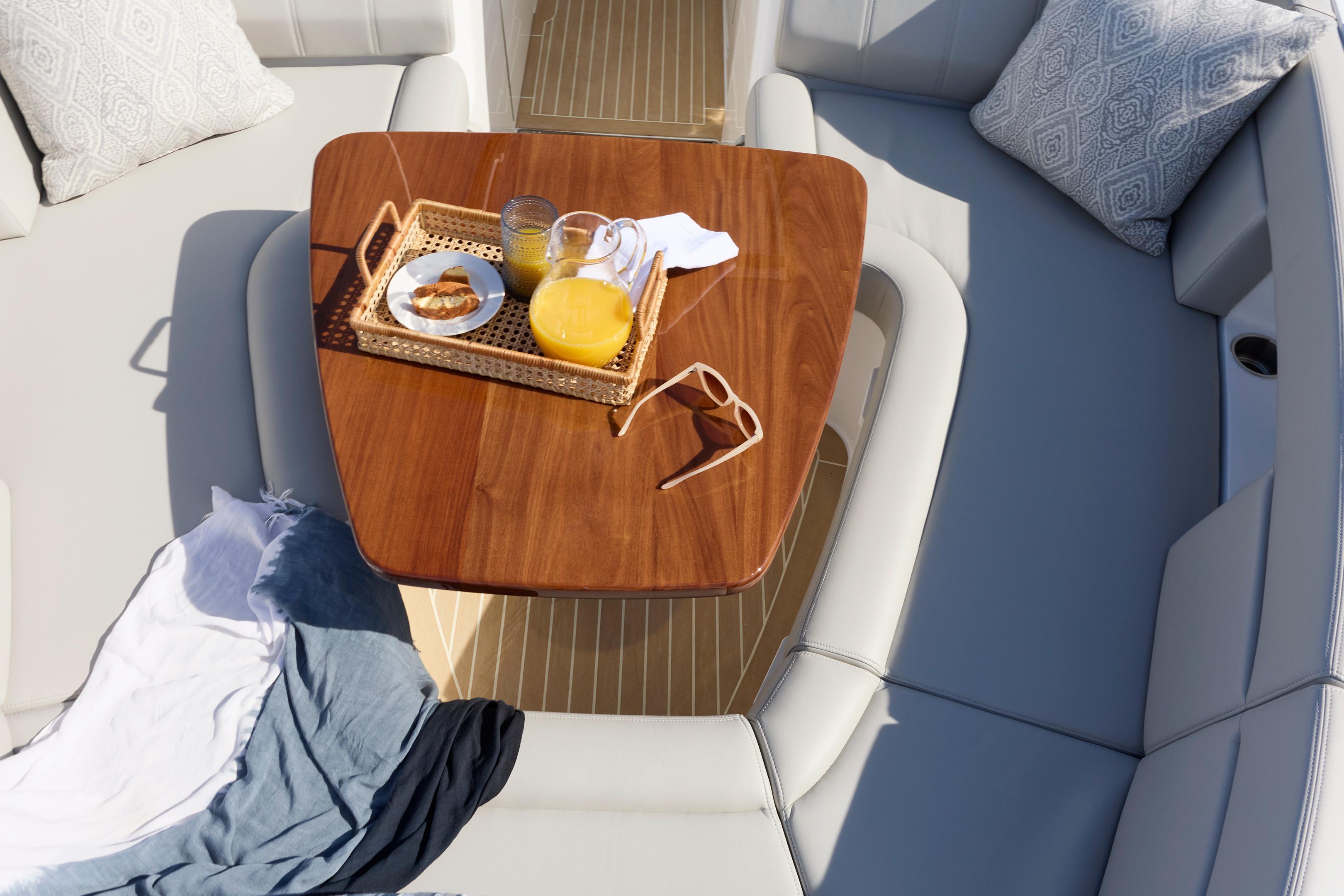Luxurious MJM 38x 2026 yacht interior with wooden table, breakfast tray, and cozy seating.