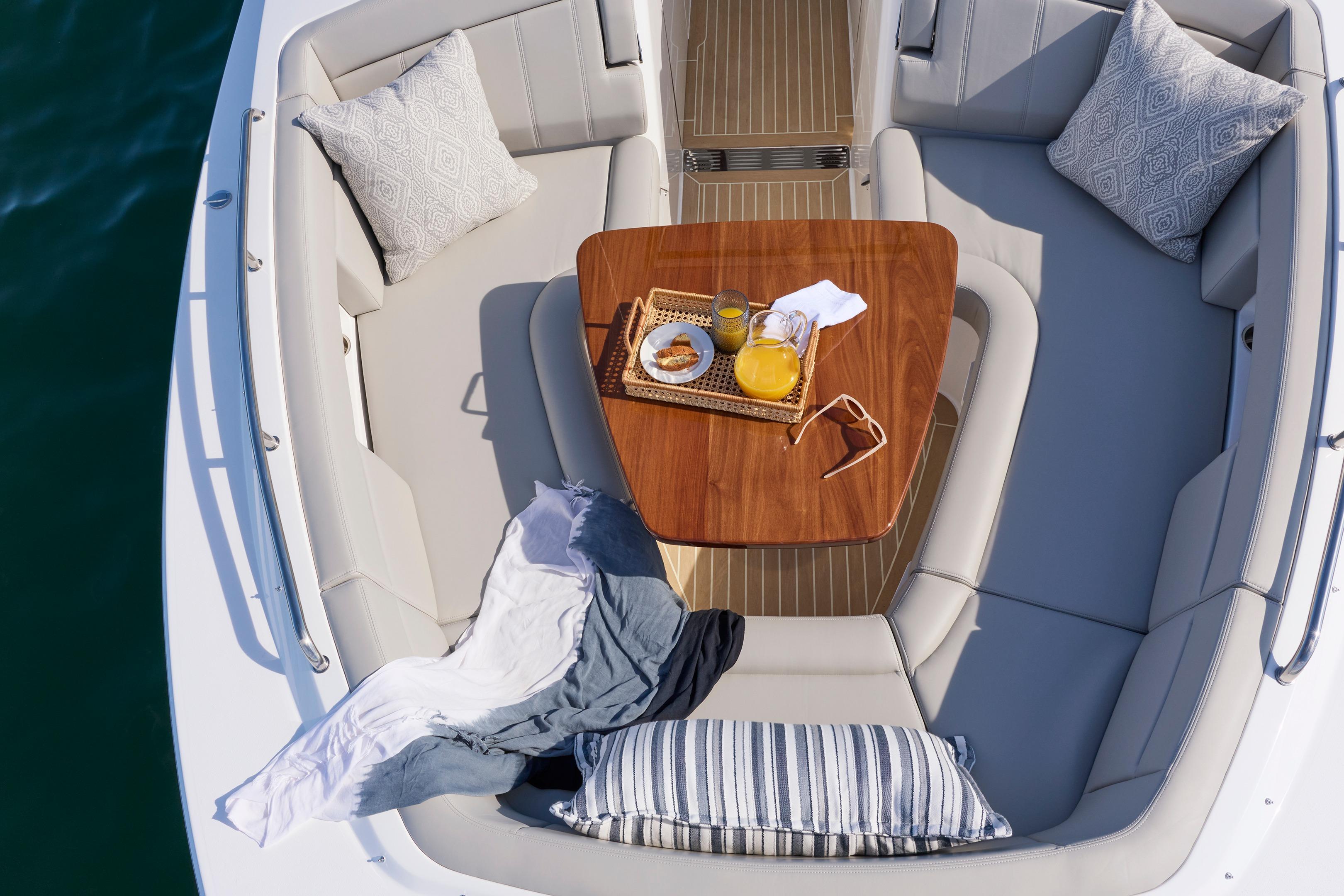 Luxurious seating area on 2026 MJM 38x boat with table and refreshments.