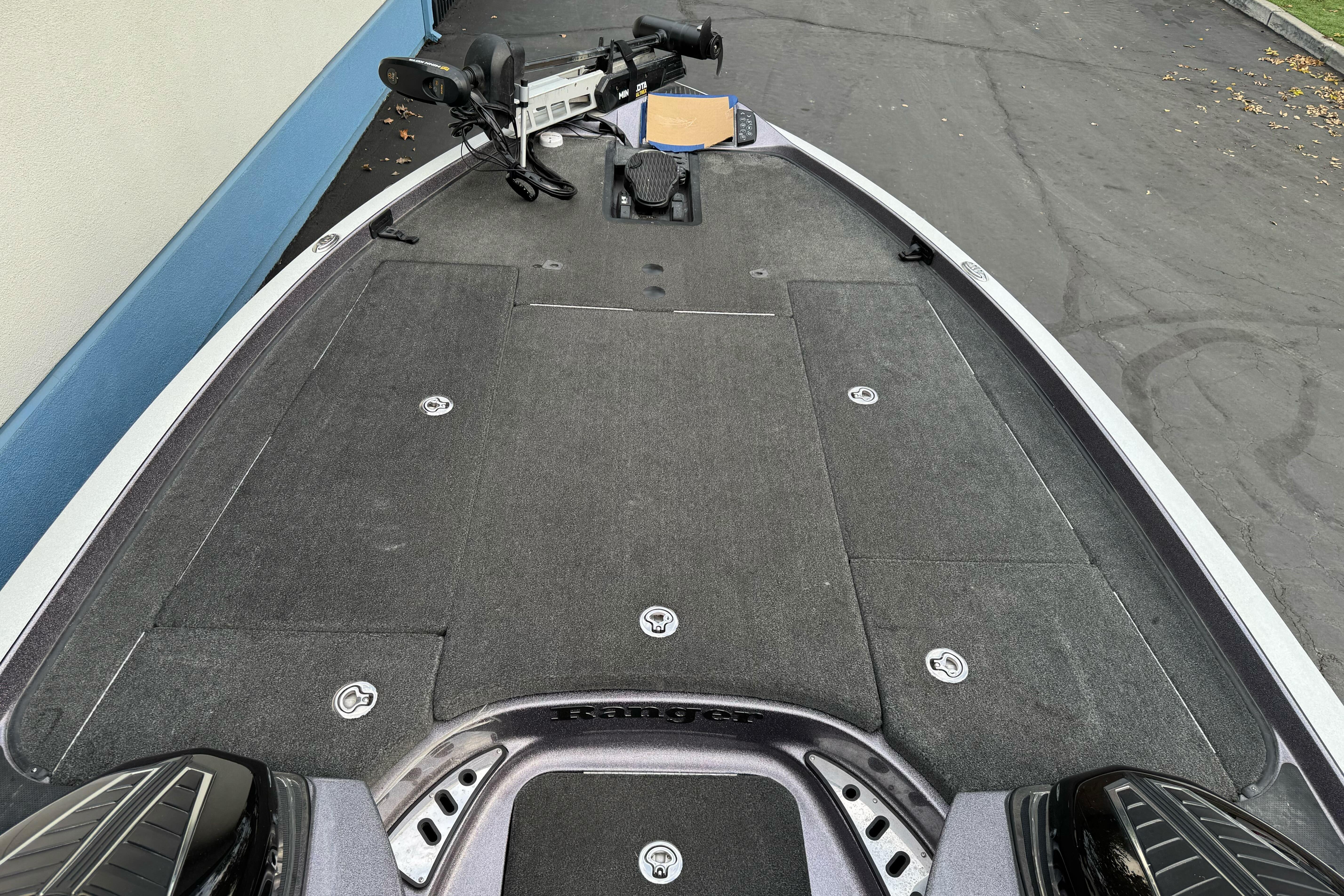 2016 Ranger Z521 Comanche boat deck with trolling motor, parked on pavement.