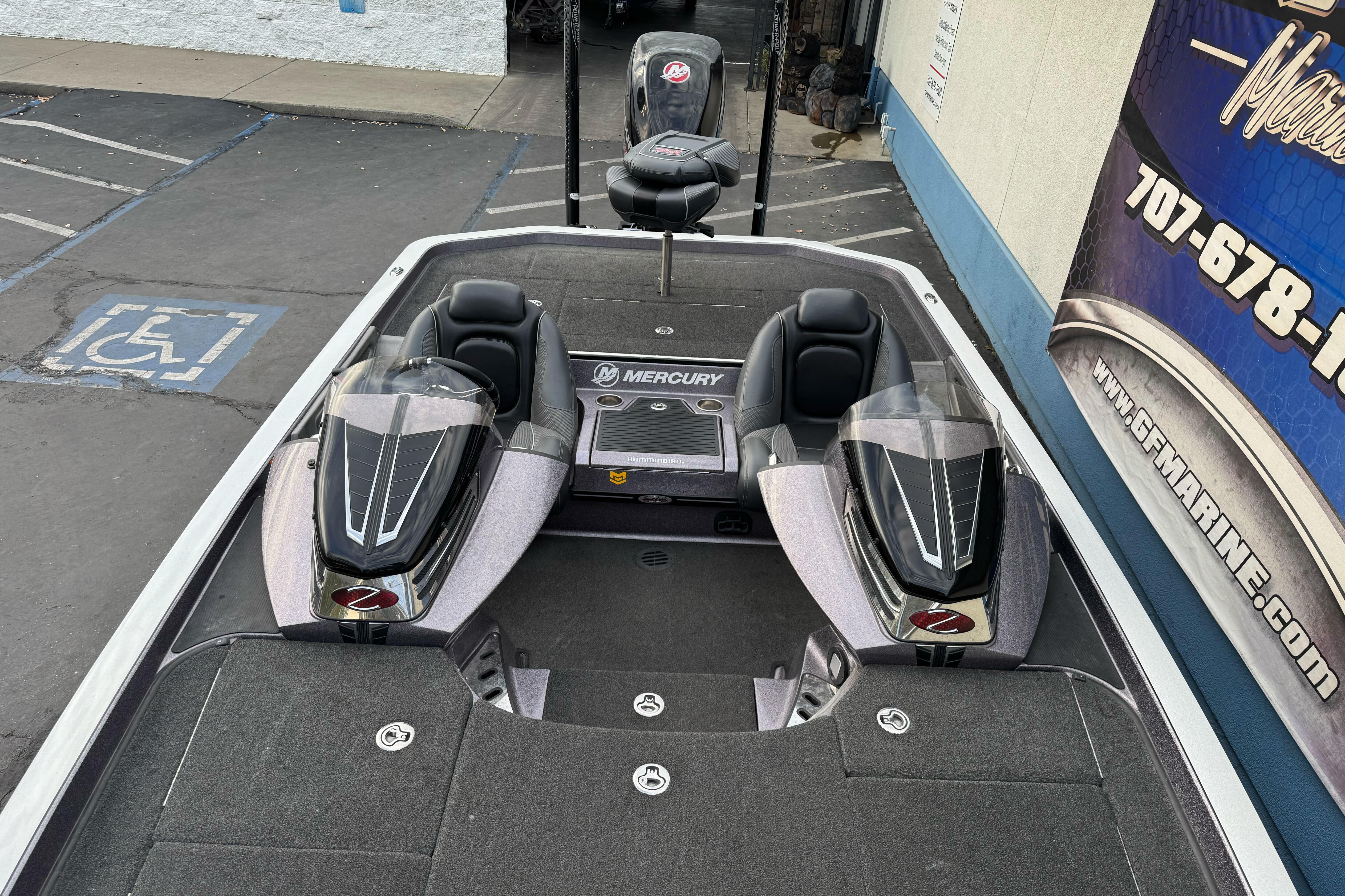 2016 Ranger Z521 Comanche boat with Mercury engine, parked near a marine shop.