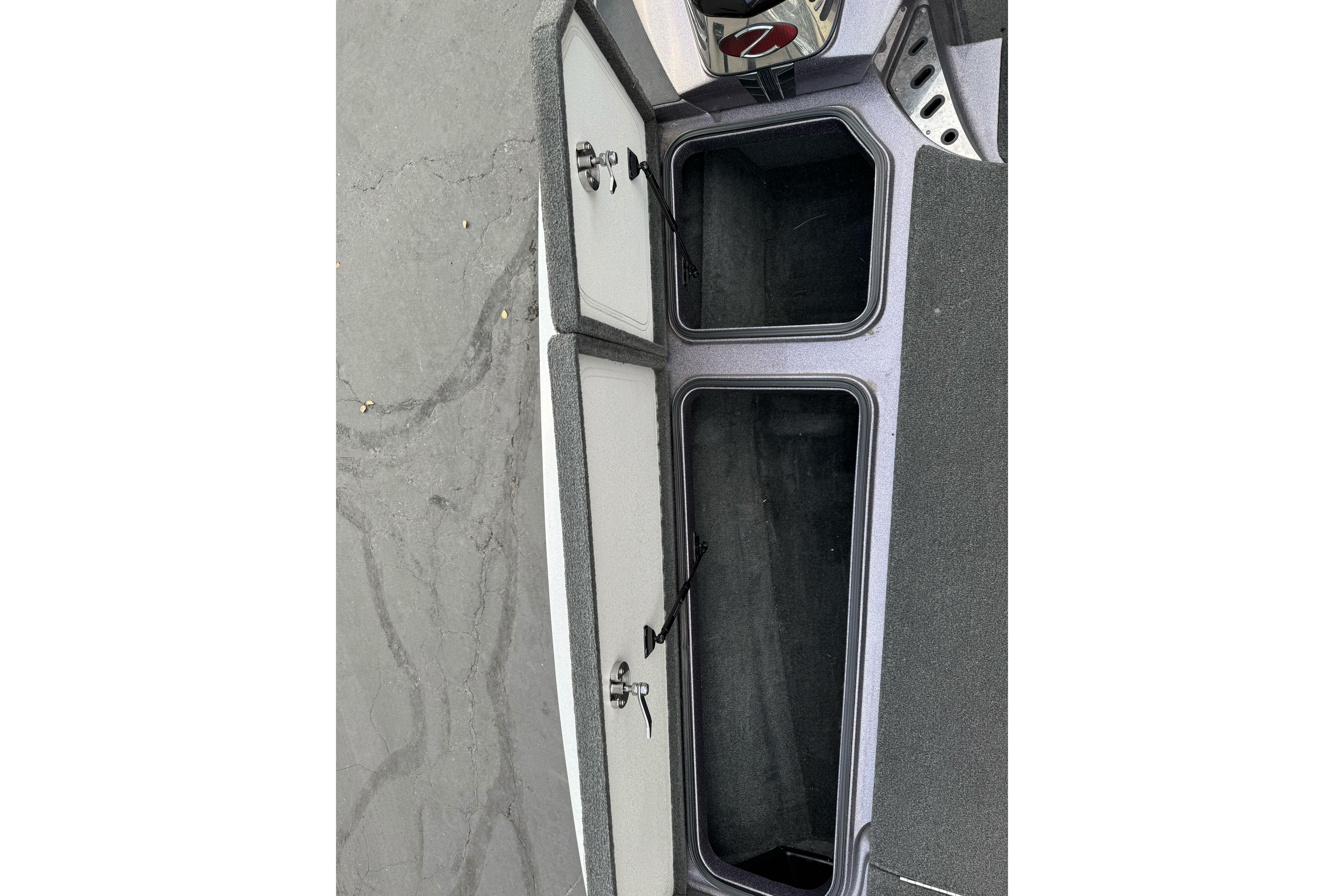 2016 Ranger Z521 Comanche boat storage compartments open on a gray surface.