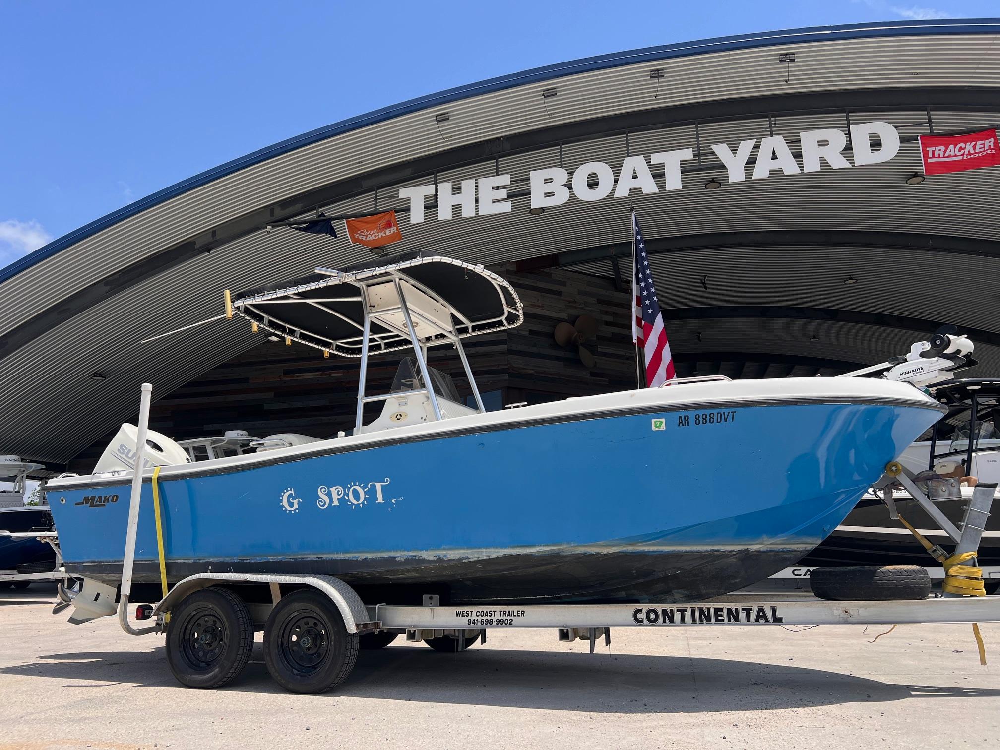1998 Mako 221 CC boat on trailer at The Boat Yard, blue hull, American flag displayed.