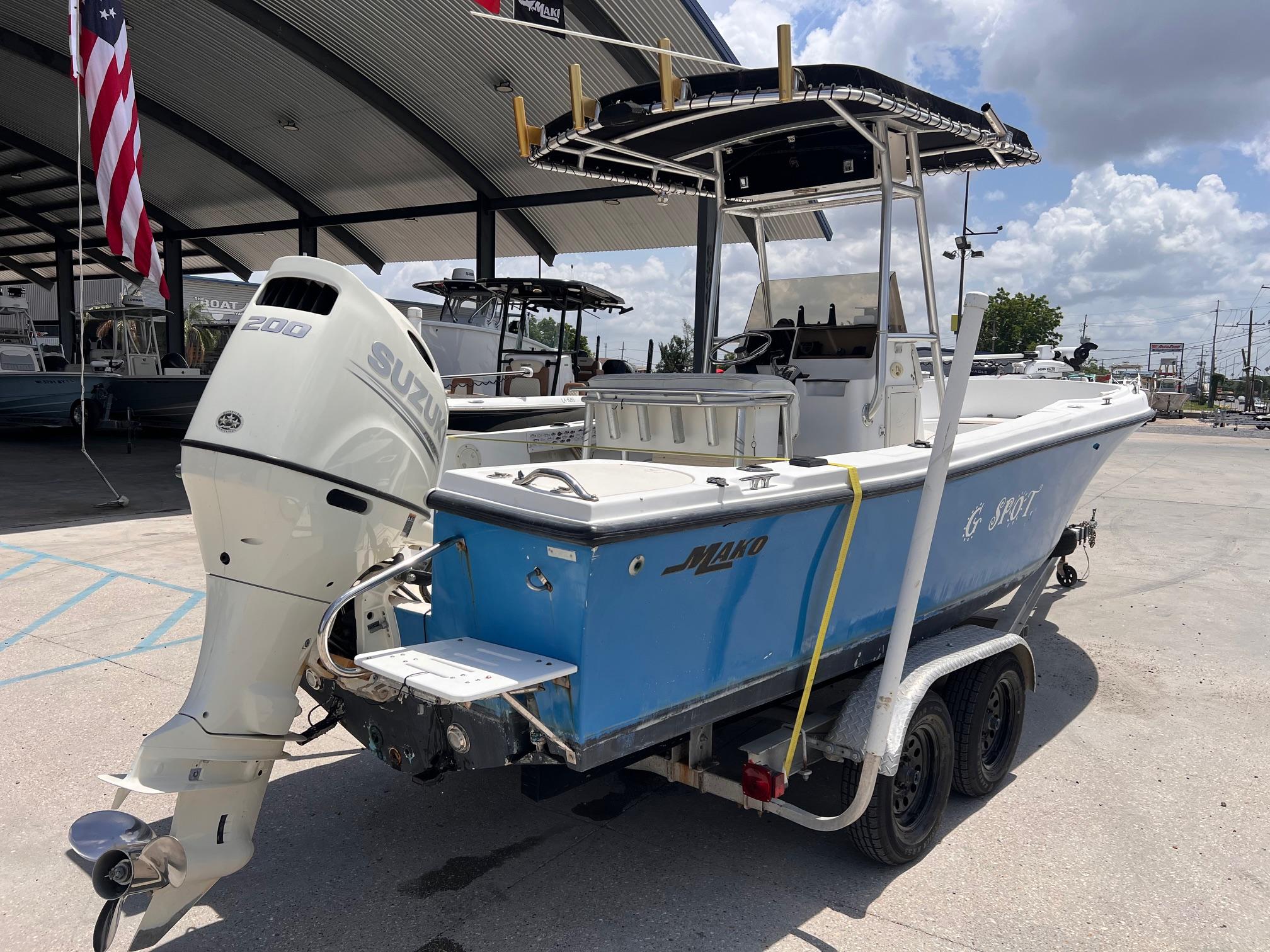 1998 Mako 221 CC boat with Suzuki 200 engine on trailer, parked outdoors.