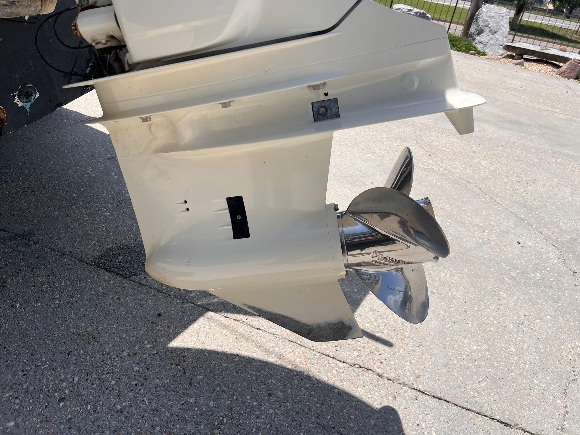 1998 Mako 221 CC boat propeller and lower unit on concrete surface.